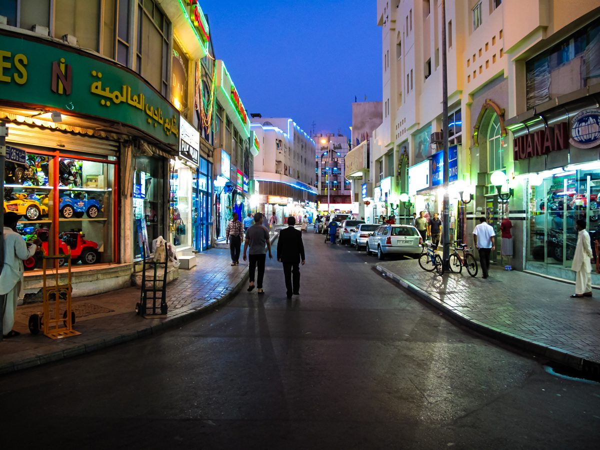 Local shops and restaurants on a street in Deira at night