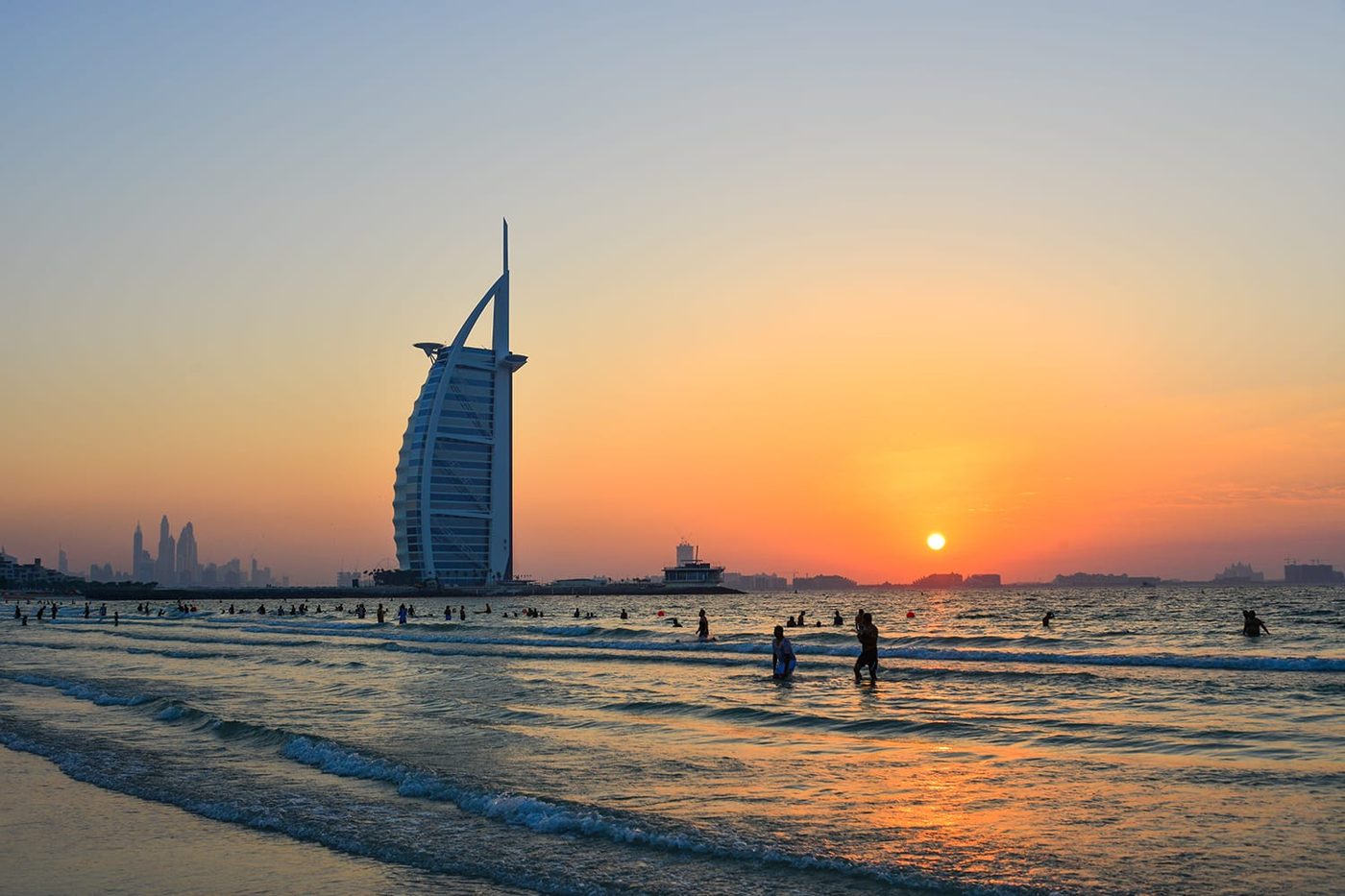 Swimmers at Sunset Beach with the Burj Al Arab behind them