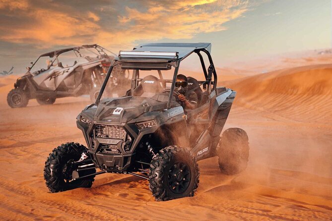 Dune buggy driving across the Dubai dunes at sunset on an adventure desert tour