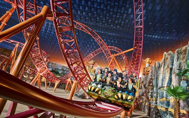 Child looking up at a huge indoor rollercoaster