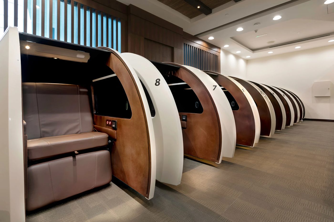 A quiet airport lounge with reclining chairs where passengers rest overnight
