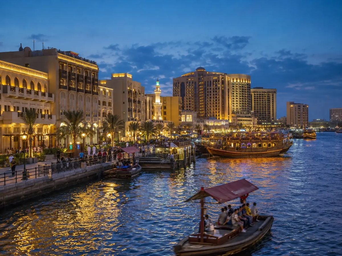 Dubai Creek and Deira lit up at night with boats on the water
