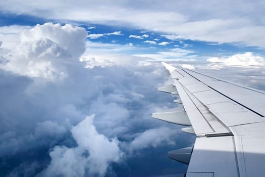 Passenger aircraft wing above the clouds on a flight to Dubai