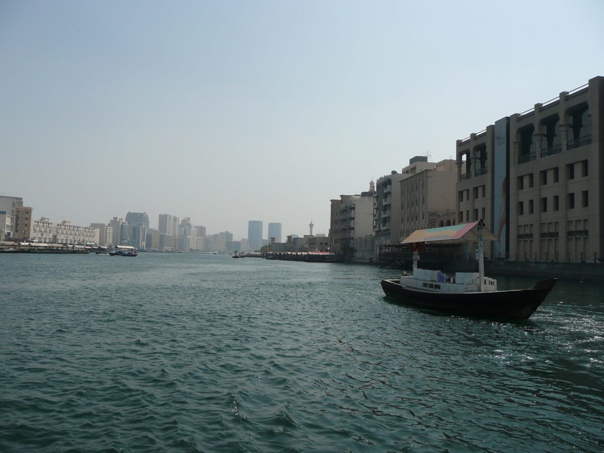 An abra boat crossing Dubai Creek with the Deira skyline behind