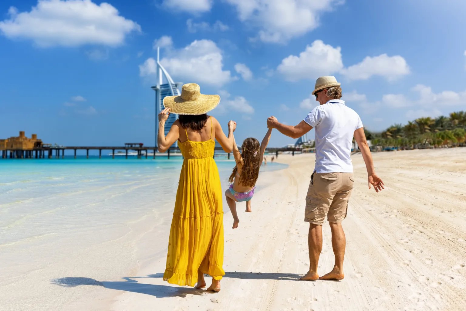 A family enjoying a Dubai beach with the skyline behind