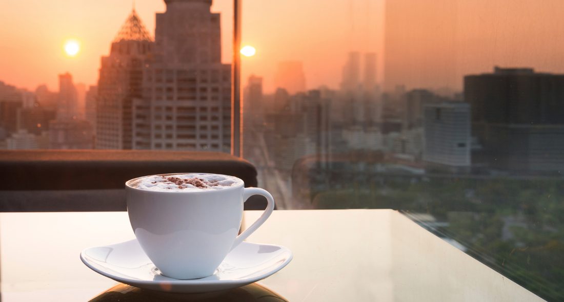 Solo traveller enjoying coffee with a Dubai skyline view