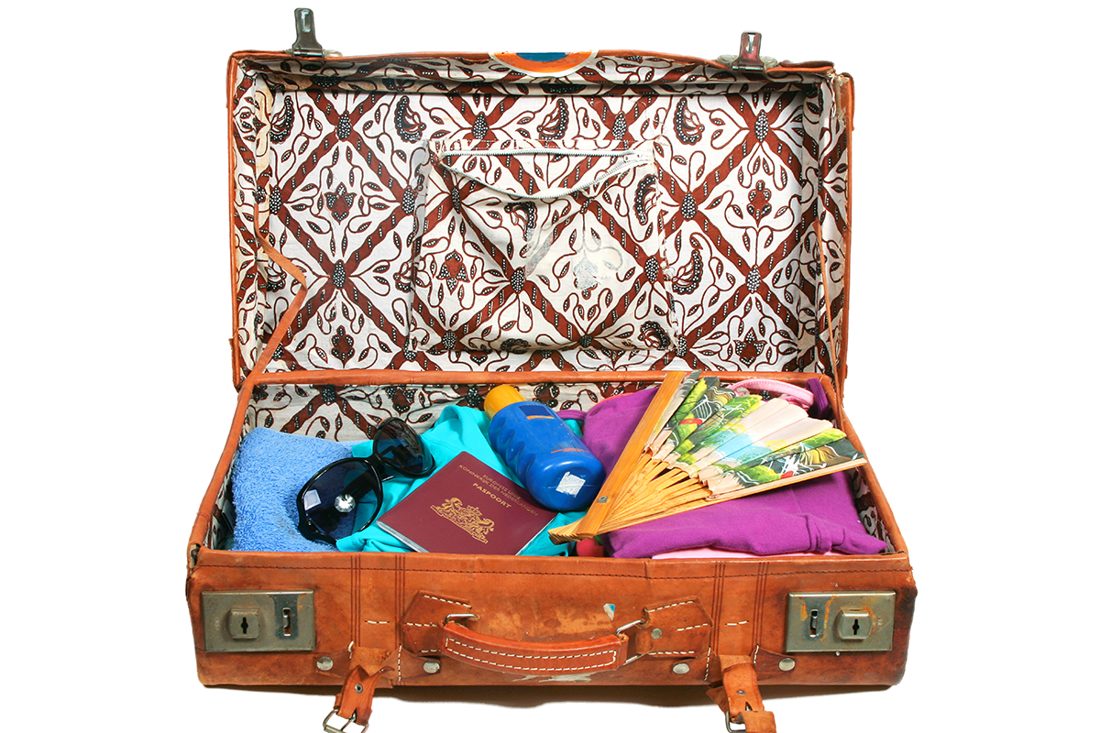 Traveller packing souvenirs into a suitcase