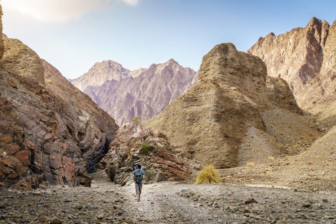 Hikers walking a rocky wadi trail in the UAE