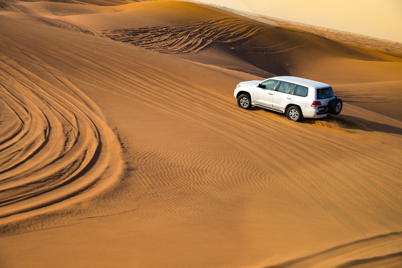 Four-wheel-drive vehicle crossing desert dunes in the UAE