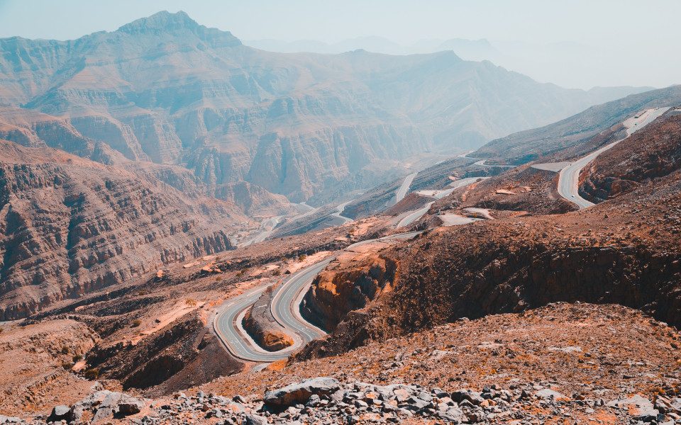 Panoramic view of Jebel Jais mountain ridges with the road visible in the valley below