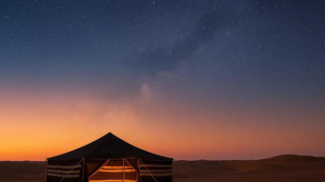 Bedouin-style tent and a resting camel beside a campfire in the Dubai desert at dusk